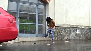 Seductive dark haired girl makes piss outdoors during rainy day